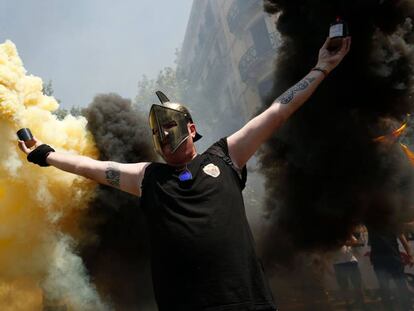 Un taxista sostiene bengalas mientras los manifestantes se reúnen frente a la delegación gubernamental.