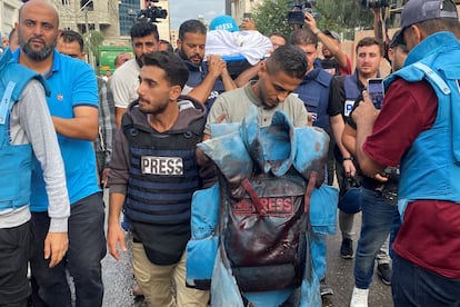 Un periodista sujeta un chaleco antibalas manchado de sangre que pertenecía al reportero palestino Mohammed Soboh, quien murió junto con otros dos compañeros cuando un misil israelí alcanzó un edificio donde estaban informando en Gaza, el día 10. 