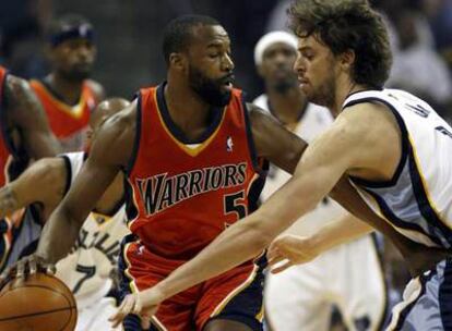 El jugador Baron Davis de los Golden State Warriors, intenta alejar del balón al jugador español Pau Gasol.