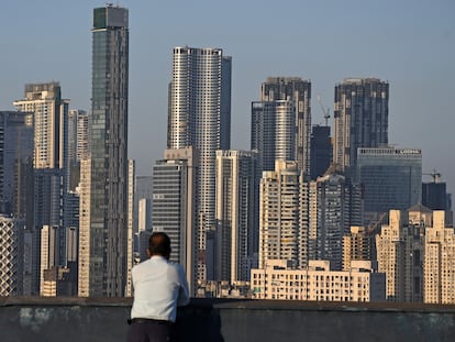 Un hombre mira hacia varios rascacielos en Mumbai, India.