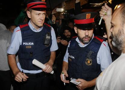 Els Mossos d'Esquadra han començat a arribar minuts abans de les 7 del matí als primers col·legis electorals que segueixen oberts i ocupats. En la imatge, agents demanen la documentació en un col·legi de Barcelona.