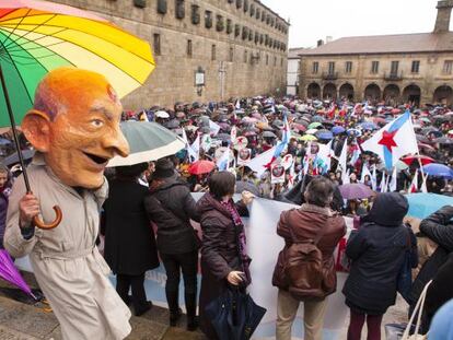 Un cabezudo representando al ministro Wert se pasea bajo la lluvia en A Quintana (Santiago) durante la manifestación por el gallego.