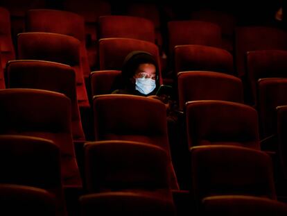 Una persona usa su teléfono móvil en el cine AMC casi vacío, mientras esperan la primera proyección el día de ayer en Burbank, California.