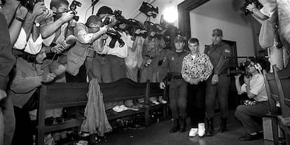 12 de mayode 1997. El acusado Miquel Ricart, a la puerta de la sala del Palacio de Justicia de Valencia, con decenas de fotógrafos, conducido por policías a la sala de vistas. Ricart se declaró no culpable en el primer día de juicio.