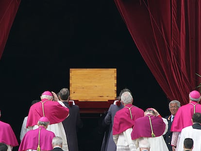 Los cardenales, vestidos con el color del luto papal (rojo), acompañan el féretro de Juan Pablo II para la ceremonia privada del enterramiento en la cripta de la basílica de San Pedro.