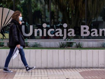 Una mujer pasa ante la sede de Unicaja en Málaga. 