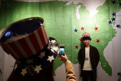 Un joven es fotografiado frente a un mapa de Estados Unidos, en Seúl (Corea del Sur).