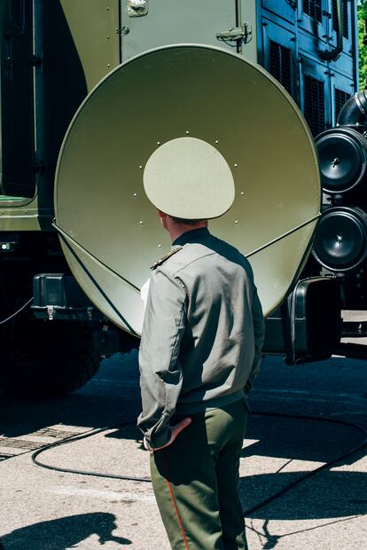 A Belarusian officer and a satellite dish fixed on a multimedia truck. Milex Expo, Minsk, Belarus, 2017.