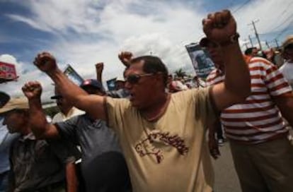 Un grupo de personas protesta con pancartas frente a un grupo de policías este jueves 20 de junio de 2013, a las afueras de la sede del Instituto Nicaragüense de Seguridad Social (INSS) en Managua (Nicaragua).