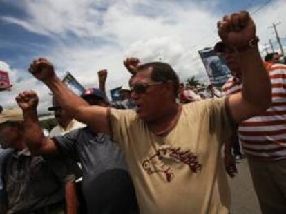 Un grupo de personas protesta con pancartas frente a un grupo de policías este jueves 20 de junio de 2013, a las afueras de la sede del Instituto Nicaragüense de Seguridad Social (INSS) en Managua (Nicaragua).