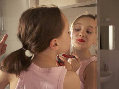 Niña se maquilla en el baño.