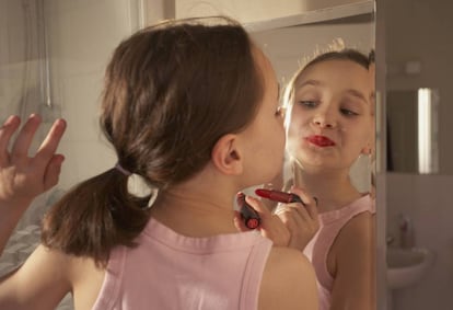 Niña se maquilla en el baño.