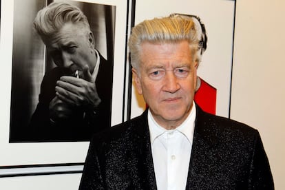 El cineasta David Lynch posa frente a uno de los retratos realizados por Karl Lagarfeld durante la inauguración de la exposición en París, en 2010.