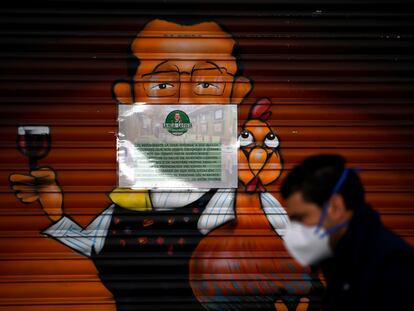 Un hombre con mascarilla camina frente a un restaurante cerrado en Madrid el 2 de abril.