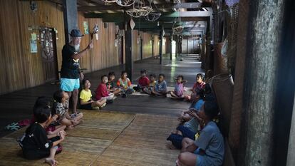 Bandi Apai Janggut habla con los niños de la comunidad dayak iban en la casa comunitaria de Sungai Utik. 