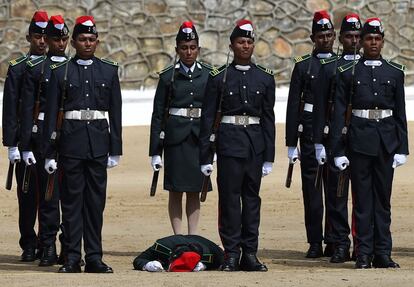 Un grupo de cadetes del ejercito de Sri Lanka escuchan el himno nacional mientras un compa?ero yace en el suelo durante la ceremonia de graduacin en Diyatalawa.