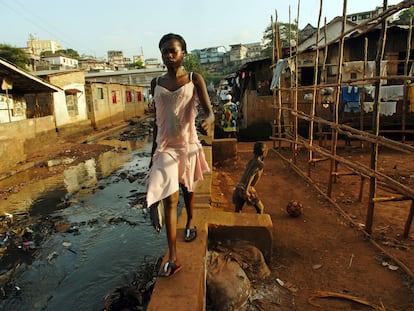 Una adolescente camina por una calle de Freetown, en Sierra Leona.