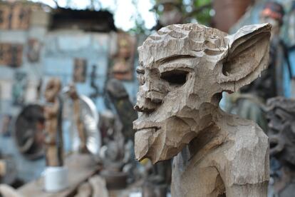 In this April 4, 2016 photo a carved wooden sculpture is displayed inside an open-air museum and art workshop off a trash-strewn street cutting through some of the poorest neighborhoods in Port-au-Prince, Haiti. The site was created in the yard of a founding member of a loose collective of Haitian artists called Atis Rezistans who have become celebrated in the international art world by creating sculptures out of scrapped car parts, old wood, discarded toys and even human skulls found scattered outside crumbling mausoleums. (AP Photo/David McFadden)