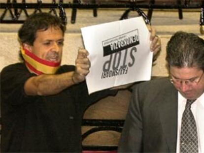 Txema Pico, juntero de Batasuna en Vizcaya, muestra un cartel a José Ignacio Echevarría, del PP.