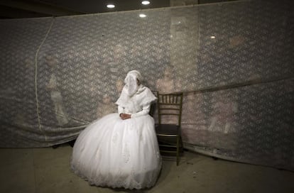 La novia Rivka Hannah, con la cara cubierta durante el rito de una boda ultraortodoxa en Jerusalén. MENAHEM KAHANA (AFP)