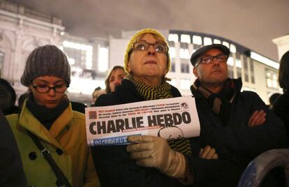 Una mujer sostiene una copia de Charlie Hebdo para rendir homenaje a las víctimas del atentado de París, frente al Parlamento Europeo en Bruselas.