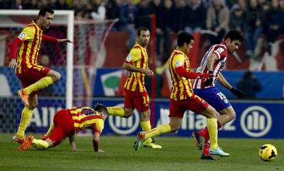 Diego Costa protege el balón ante el acoso de los jugadores del Barcelona