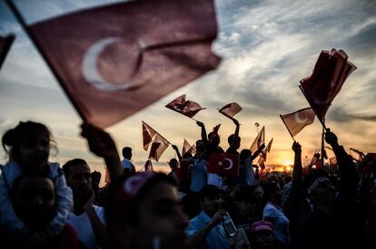 La gente agitar banderas nacionales turcas durante un mitin para conmemorar el aniversario de la conquista de Estambul.