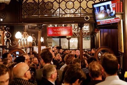 Un grupo de personas ven desde el televisor de un bar de Londres (Reino Unido) la rueda de prensa de la primera ministra británica después de que los diputados votaran en contra del acuerdo Brexit del gobierno, el 15 de enero de 2019. Los legisladores británicos votaron abrumadoramente el martes para rechazar el acuerdo de divorcio entre Londres y Bruselas, en una votación histórica que deja a Brexit en la balanza, decisión tras la que Bruselas supedita la prórroga del Brexit a un acuerdo entre May y Corbyn.