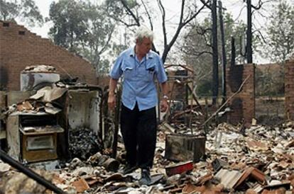Un residente de Warrimoo, cerca de Sydney, trata de recuperar algún objeto de las ruinas de su casa, abrasada por un incendio.