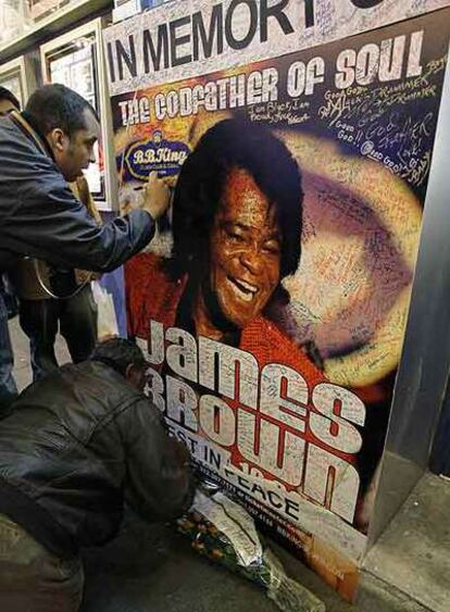 Seguidores de James Brown firman ayer en un cartel que anuncia sus actuaciones en el exterior del local de B. B. King en Nueva York.