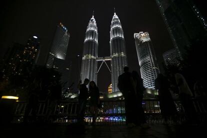 Varias personas toman fotografías de las Torres Gemelas de Petronas momentos antes del apagón simbólico con motivo de la "Hora del Planeta" en Kuala Lumpur (Malasia).