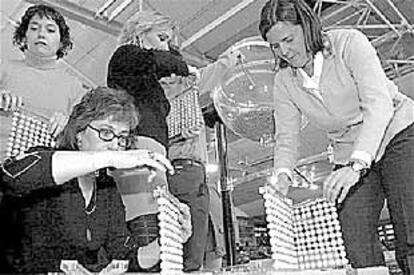 Cuatro mujeres preparan las bolas con las que se sortearán los pisos de protección de Vitoria.