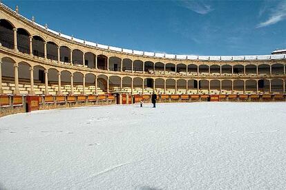 Un hombre y un niño, ayer, sobre la nieve acumulada en la plaza de toros de Ronda.