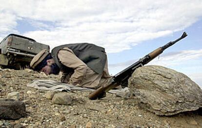 Un guerrillero antitalibán reza junto a su fusil cerca de Tora Bora.