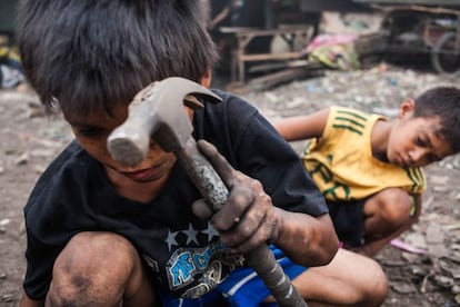 Clint, de 11 años, golpea con un martillo una madera para sacar los clavos y venderlos posteriormente. Mientras que son pequeños, recogen trozos de metal entre los restos del carbón, pero según van haciéndose mayores las tareas son más exigentes y empiezan a trabajar con herramientas. A esta edad, extraer clavos, transportar madera, recoger el carbón e introducirlo en los sacos, o limpiar los hornos son algunas de las labores que ya están capacitados para desempeñar.