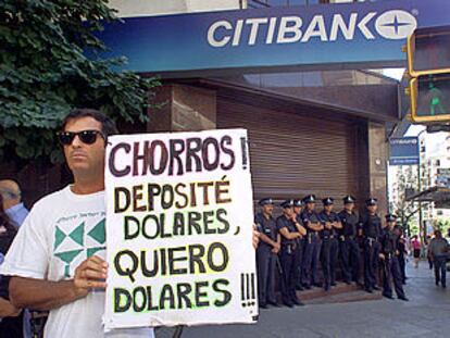 Un argentino exhibe en Buenos Aires un cartel que acusa de &#39;chorros&#39; (ladrones) a los directivos de los bancos.