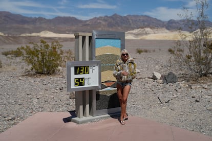 A woman poses with a thermometer in the national park, on July 16, 2023.