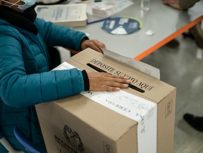 Una persona deposita su voto en urna, en un colegio electoral en Bogotá, en una imagen de archivo.