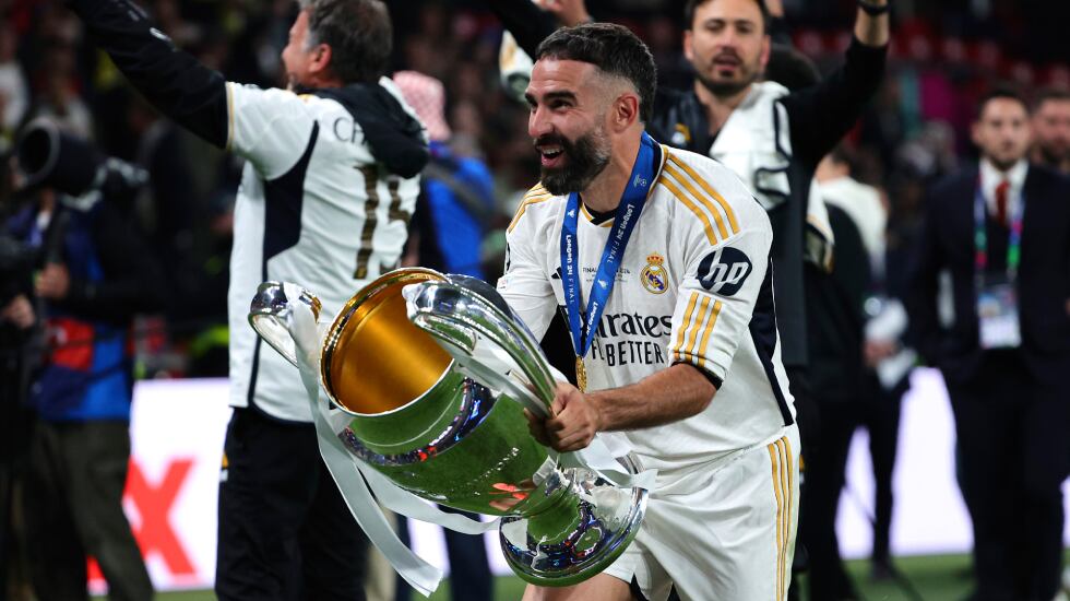 Dani Carvajal corre por el campo con el trofeo de la última Champions ganada por el Real Madrid.
