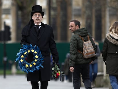 Homem carrega guirlanda em símbolo da União Europeia na praça do Parlamento, em Londres, nesta sexta-feira.