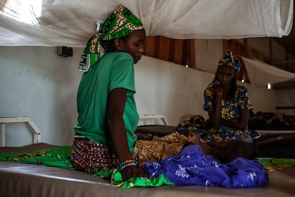 Djeuda Mussa cuida de su hija, Hadi, de un año y enferma de rubeola, en el hospital de Mora, en Camerún. Al fondo, la abuela de la niña acompaña.