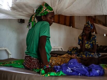 Djeuda Mussa cuida de su hija, Ada, de un año y enferma de rubeola, en el hospital de Mora, en Camerún. Al fondo, la abuela de la niña acompaña.