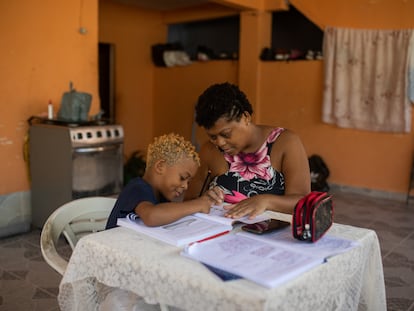 Uma mãe ensina a tarefa escolar ao filho em casa, no Rio de Janeiro.