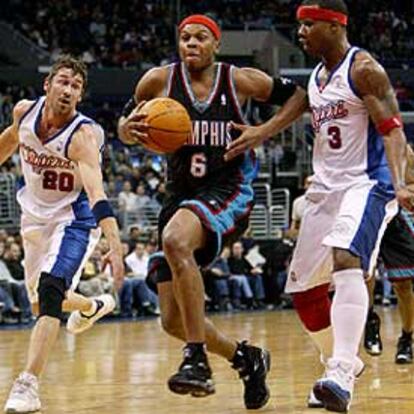 El jugador de los Grizzlies Bonzi Wells avanza con el balón entre Jaric (izqda.) y Richardson, de los Clippers.