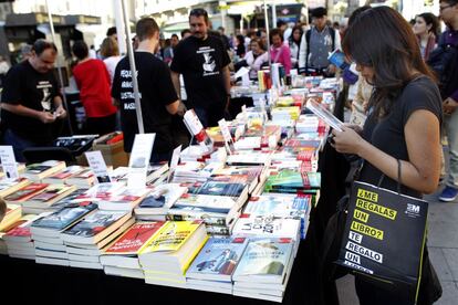 Una mujer observa un libro en la plaza de Callao de Madrid.