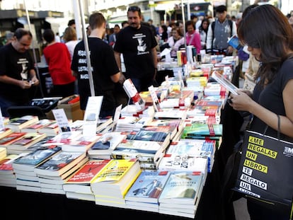 Una mujer observa un libro en la plaza de Callao de Madrid.