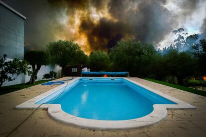 Un incendio arde cerca de una piscina durante un incendio forestal en el pueblo de Lavradio, Ourem, Portugal, este miércoles.