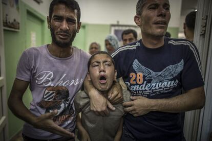 Varias personas lloran la muerte de un familiar, que fue asesinado en el bombardeo israelí a la escuela de la localidad de Beit Hanún.