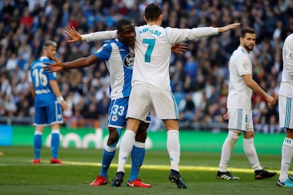 El delantero portugués del Real Madrid, Cristiano Ronaldo (d) y el defensa del Deportivo de la Coruña, Steve Aldo One (i), durante el partido.