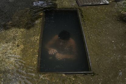 Un niño se sumerge para refrescarse en el sitio de una tubería de agua rota en una calle de Caracas, Venezuela, el 27 de julio.